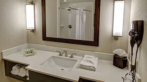 A bathroom with a sink, mirror, towel rack, and hairdryer. - Holiday Inn Hotel & Suites Tupelo North by IHG (Tupelo)