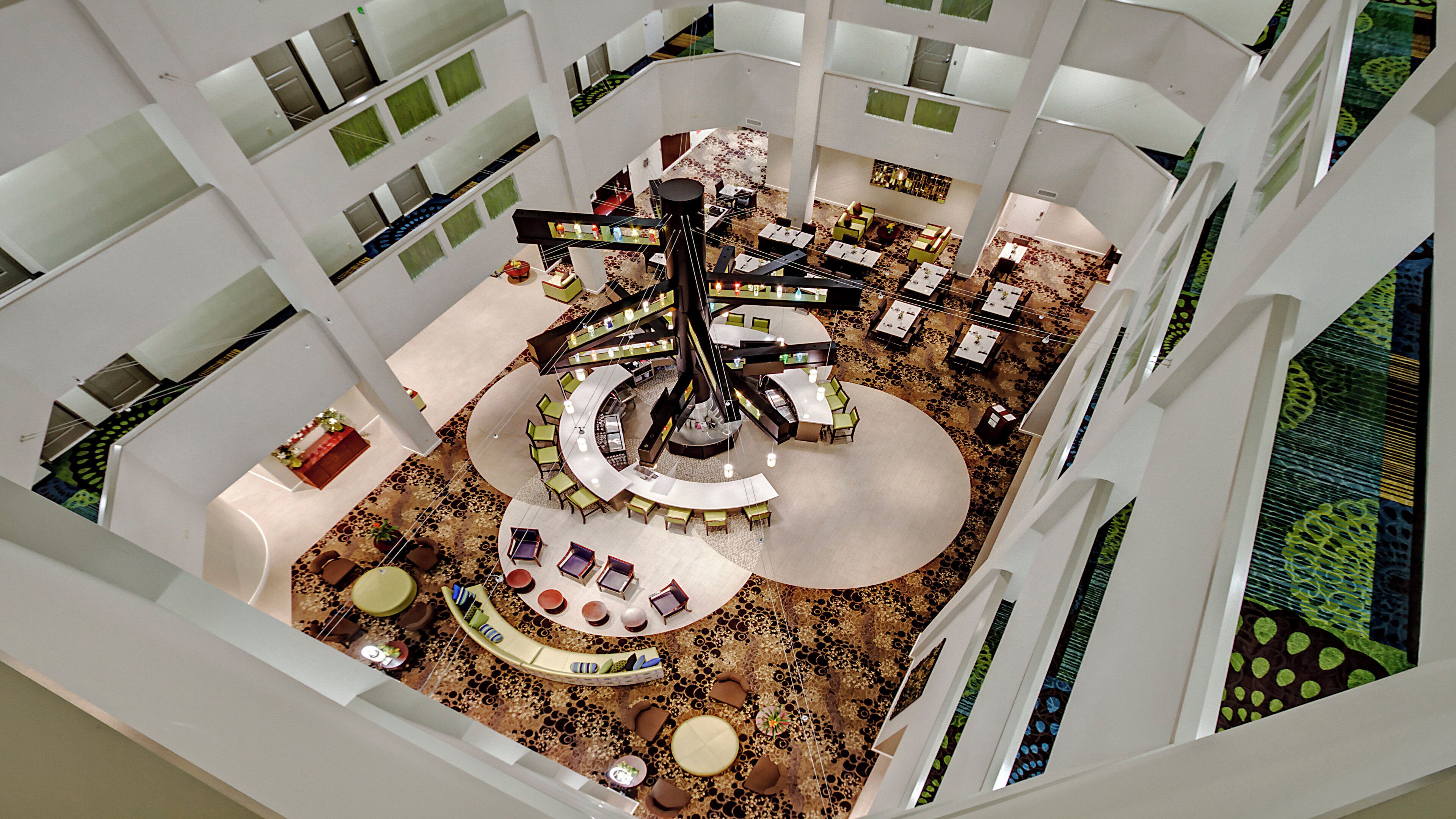 Un atrium à plusieurs niveaux doté d’un espace central circulaire avec des sièges, de nombreuses tables et une variété d’options d’aménagement pour s’asseoir.