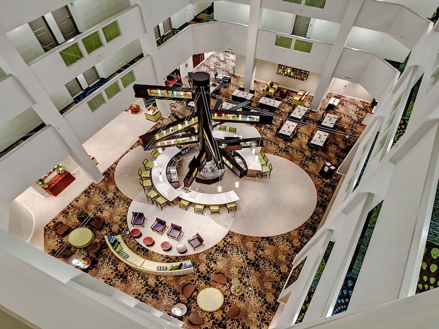 Un atrio de varios niveles con una zona de estar circular central, varias mesas de comedor y una variedad de opciones de asiento.
