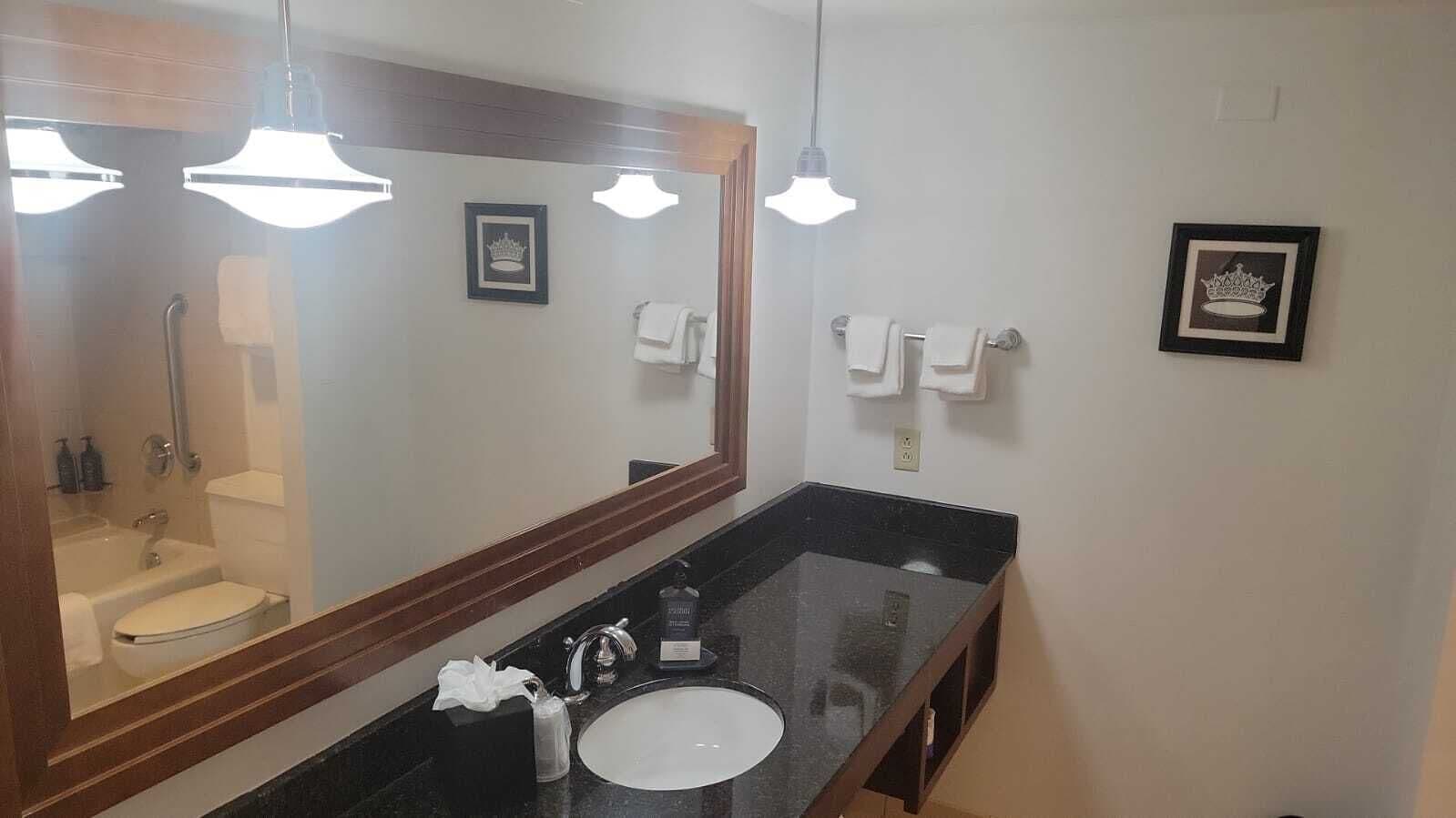 Een bad/douchecombinatie, designer toiletartikelen, een haardroger