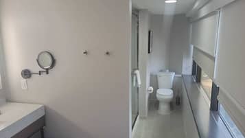 A compact bathroom with a toilet, a sink, and a mirror.