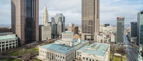 A cityscape with modern skyscrapers, historic buildings, and a large central building with a dome.