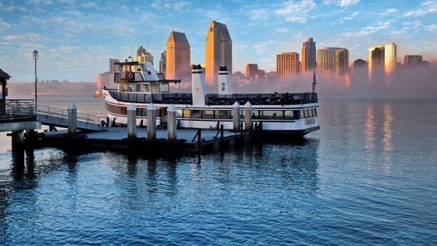 A riverboat docked at a pier with a city skyline in the background. - Mission View Inn & Suites San Diego Sea World - Zoo (San Diego)