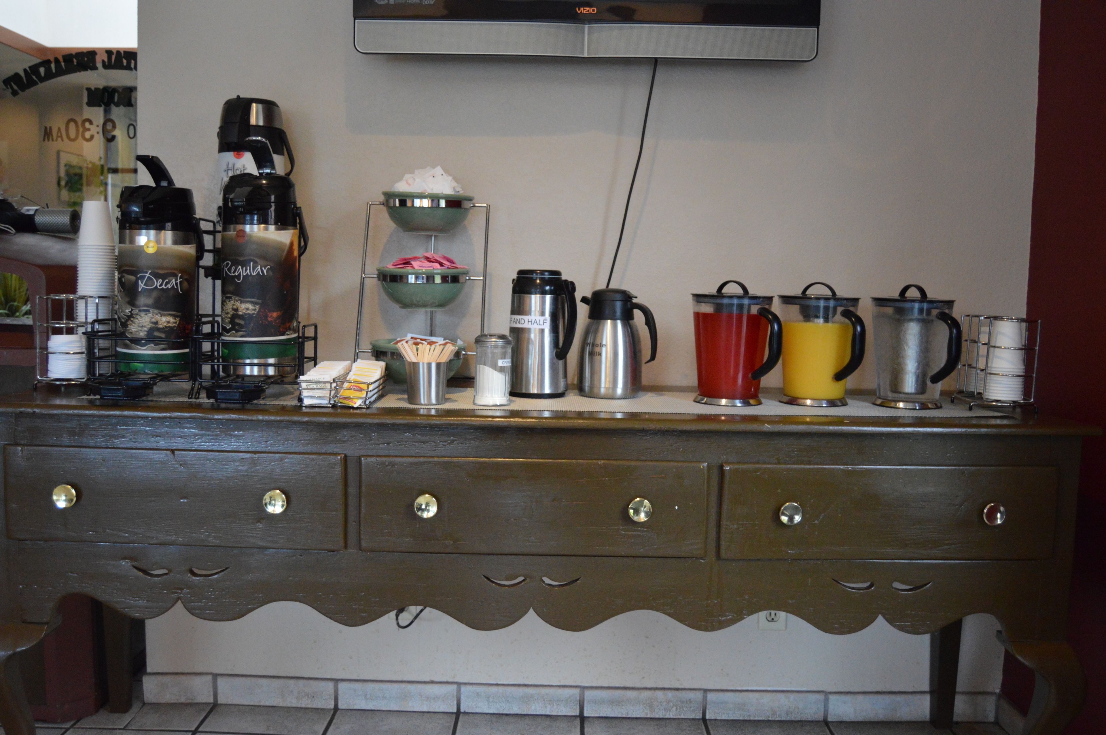 A kitchen counter with various coffee makers and containers.