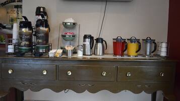 A kitchen counter with various coffee makers and containers.