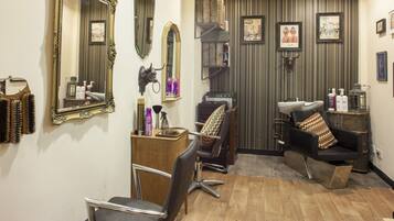 A salon with two chairs, mirrors, and a sink.