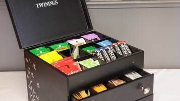 A black box with compartments containing various branded coffee packets.
