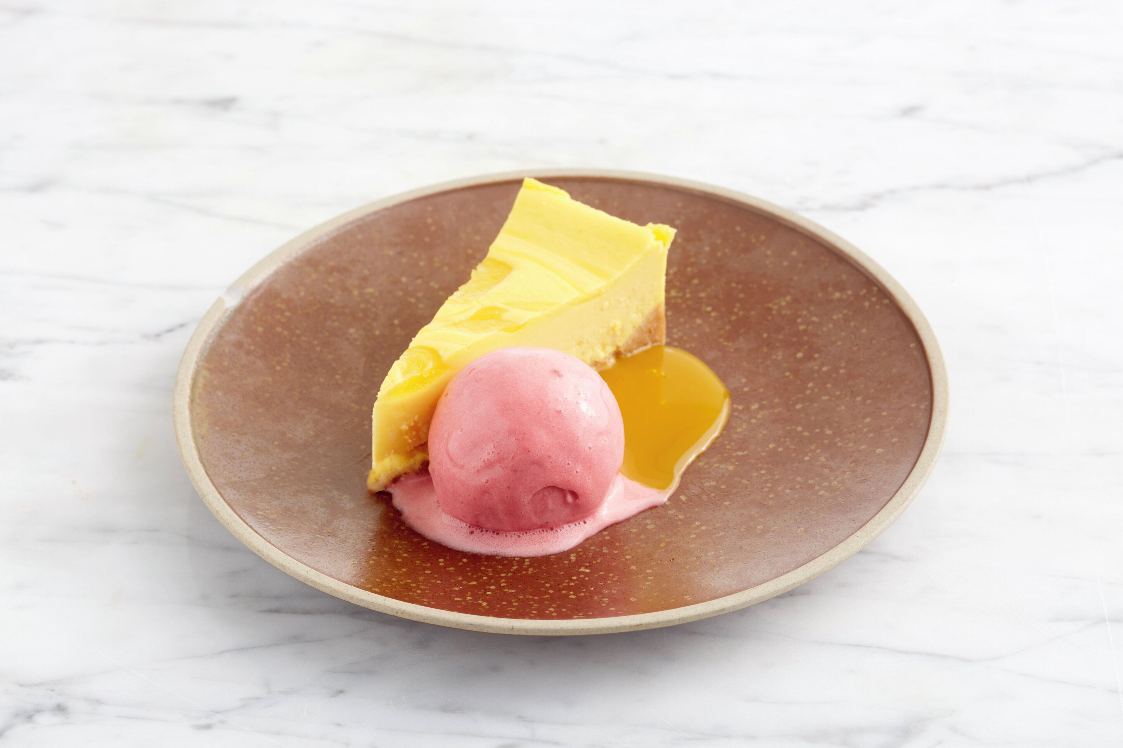 Un postre sobre un plato con fondo de mármol.