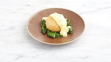 A plate with a food item on a marble surface.