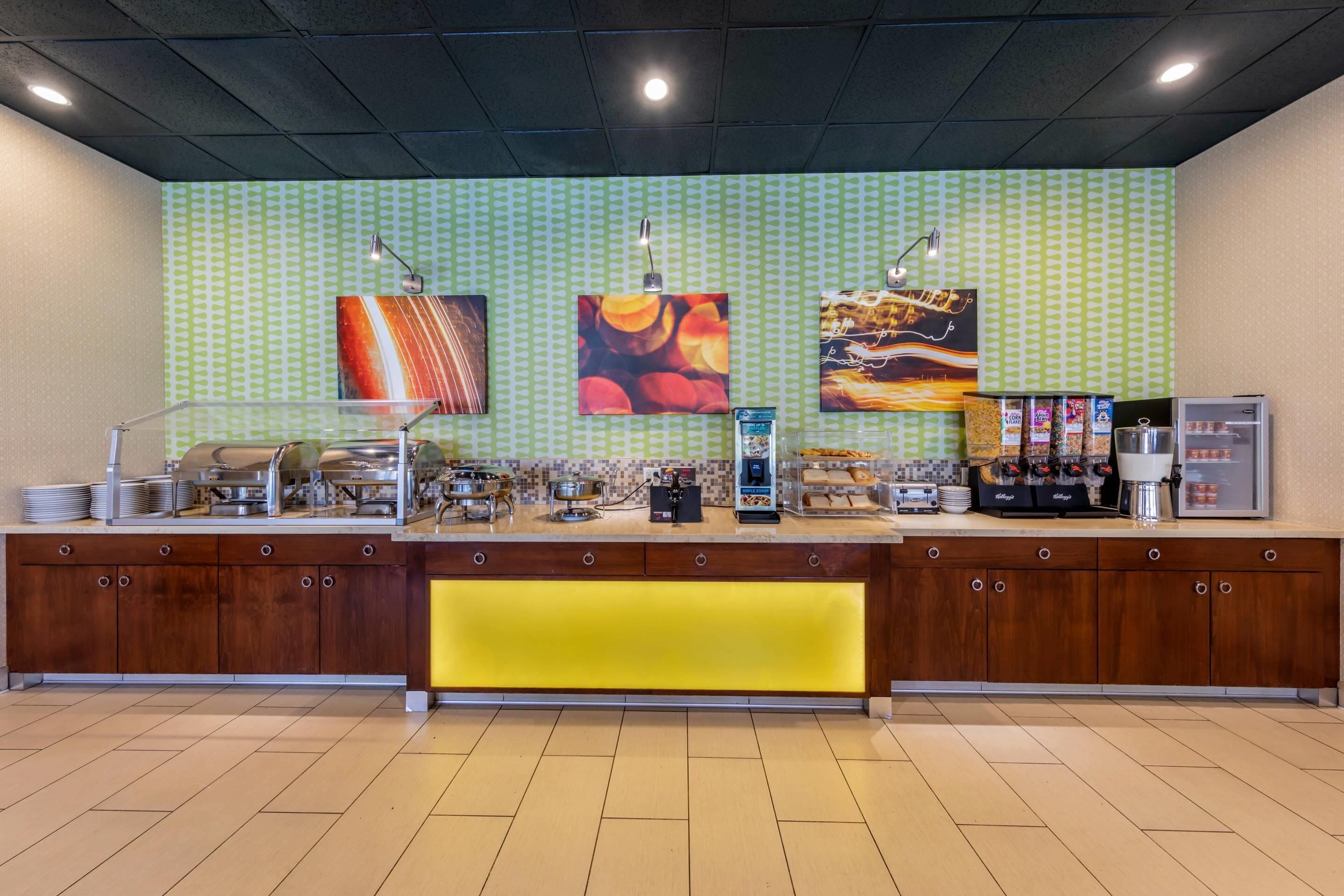 A buffet counter with multiple food stations, a coffee machine, and a refrigerator.