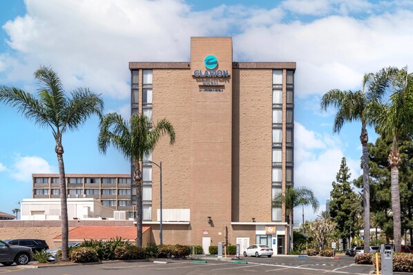 A hotel building with a prominent sign reading "GLARION HOTEL" and a logo above it.