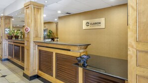 A reception desk with a wooden finish, a sign for Clarion by Choice Hotels, and a security keypad.