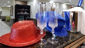 A room with a marble countertop, a red glittery hat, and three clear champagne flutes. - Comancheria Hotel & Convention Center (Lawton)