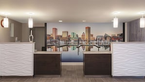 A reception area with two reception desks, a cityscape mural, and a clock on the wall.