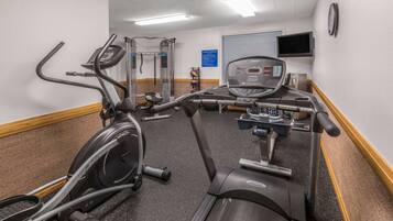 A gym with treadmills, elliptical machines, and weightlifting equipment.