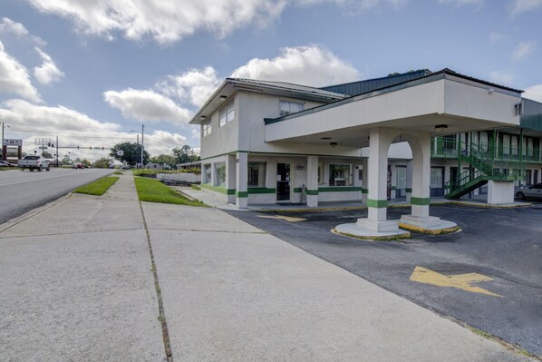 Un edificio con una estación de servicio, una zona de estacionamiento techada y una escalera.