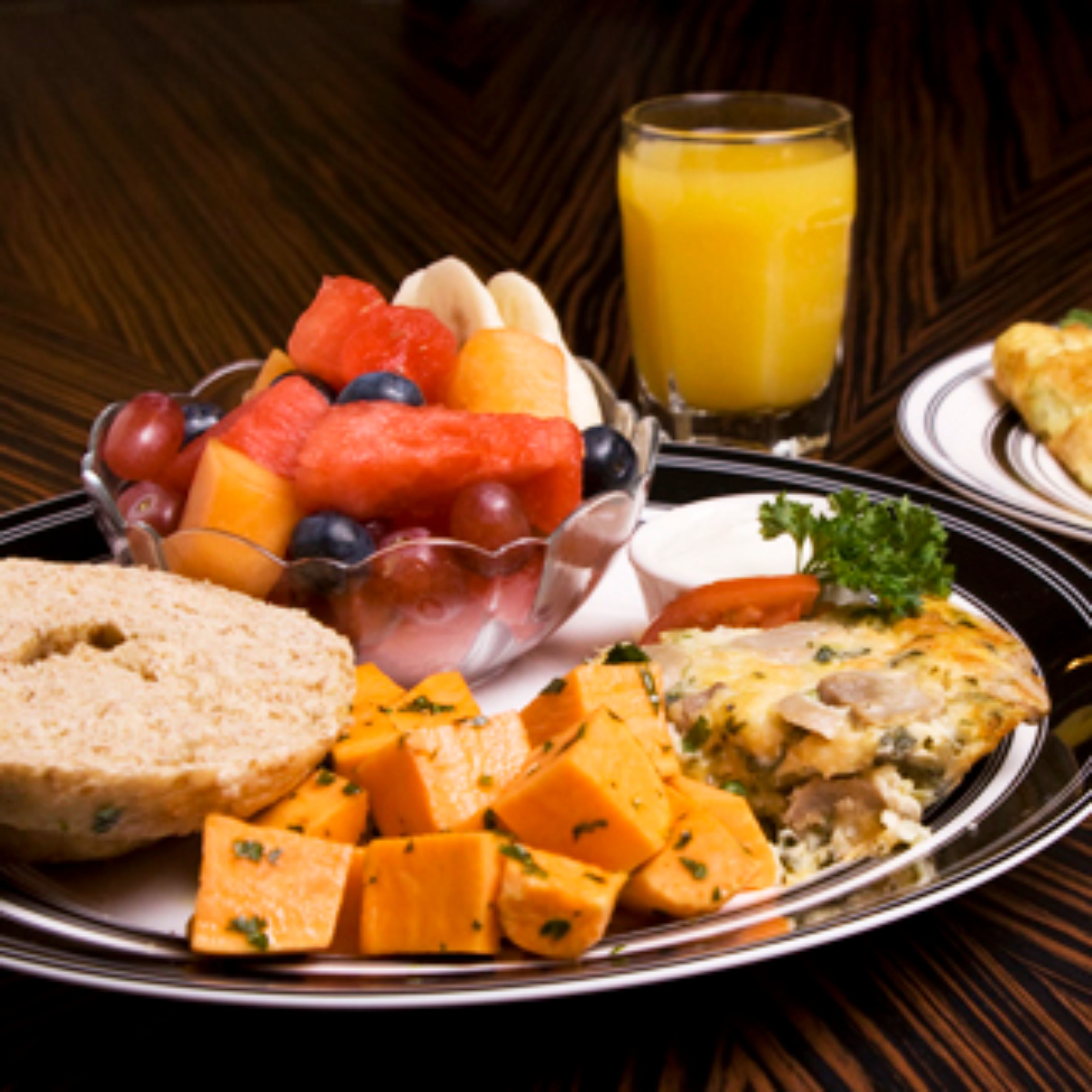Une assiette de petit-déjeuner avec des toasts, des fruits et une part de tarte.