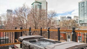 A hot tub on a deck with a city skyline in the background. - Queen Anne Bed And Breakfast (Denver)