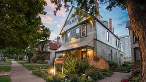 A two-story building with a stone facade, a visible entrance, and a signboard. - Queen Anne Bed And Breakfast (Denver)