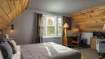 Ein Schlafzimmer mit Bett, Schreibtisch, Stuhl, Kommode und Fernseher.