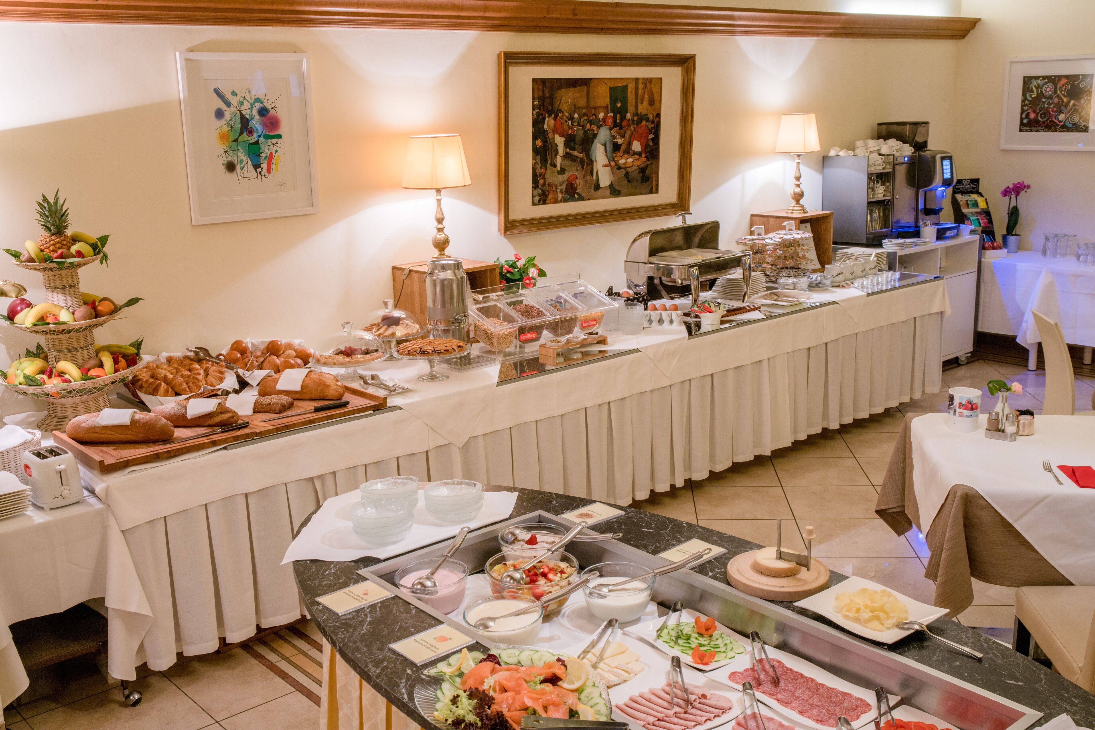 A buffet setup with various food items and a coffee station.