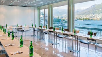 Un salón de conferencias con vistas panorámicas a un lago y montañas.