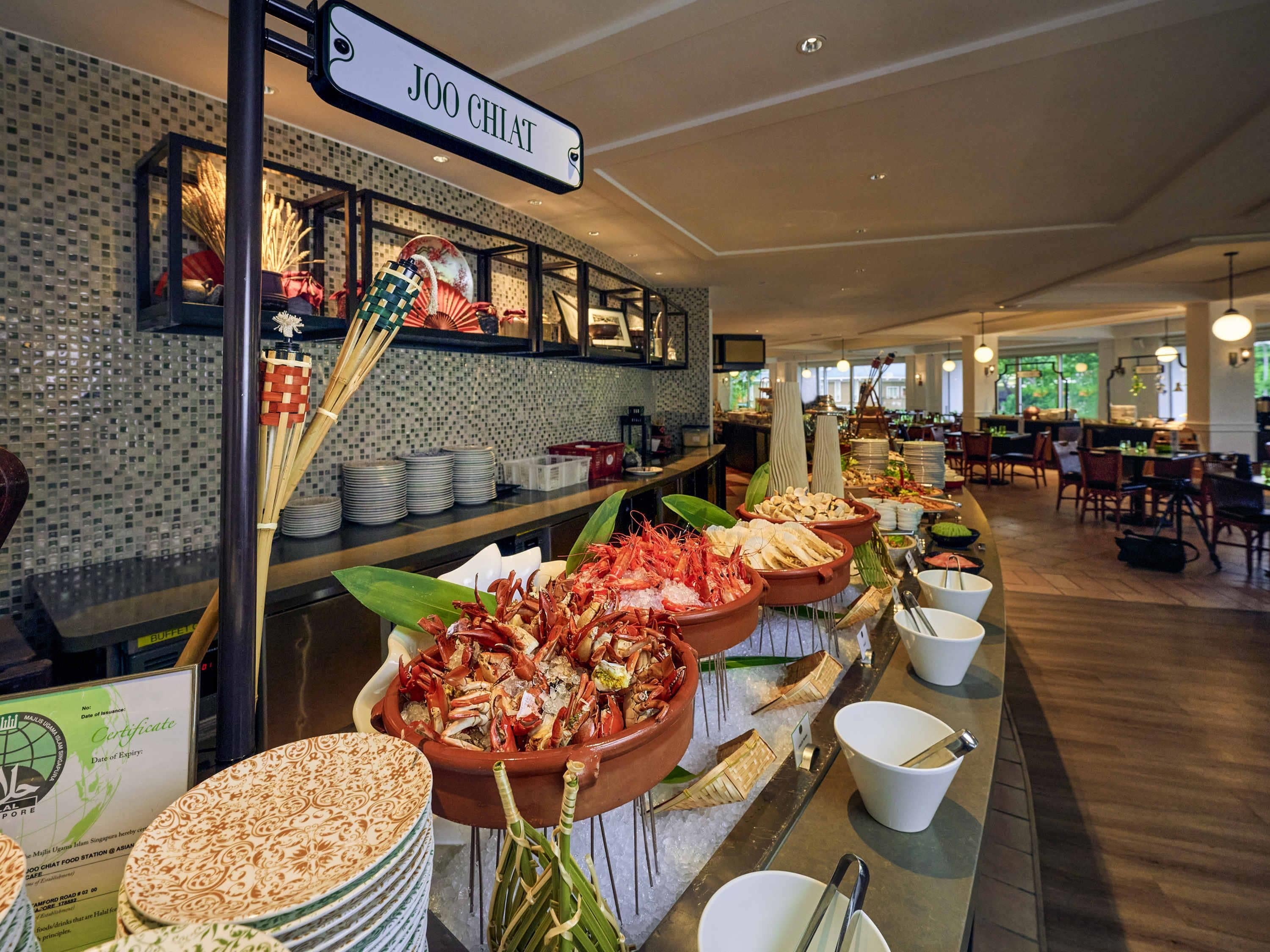 A buffet area with seafood dishes, a certificate display, and a sign reading 'JOO CHIAT'.