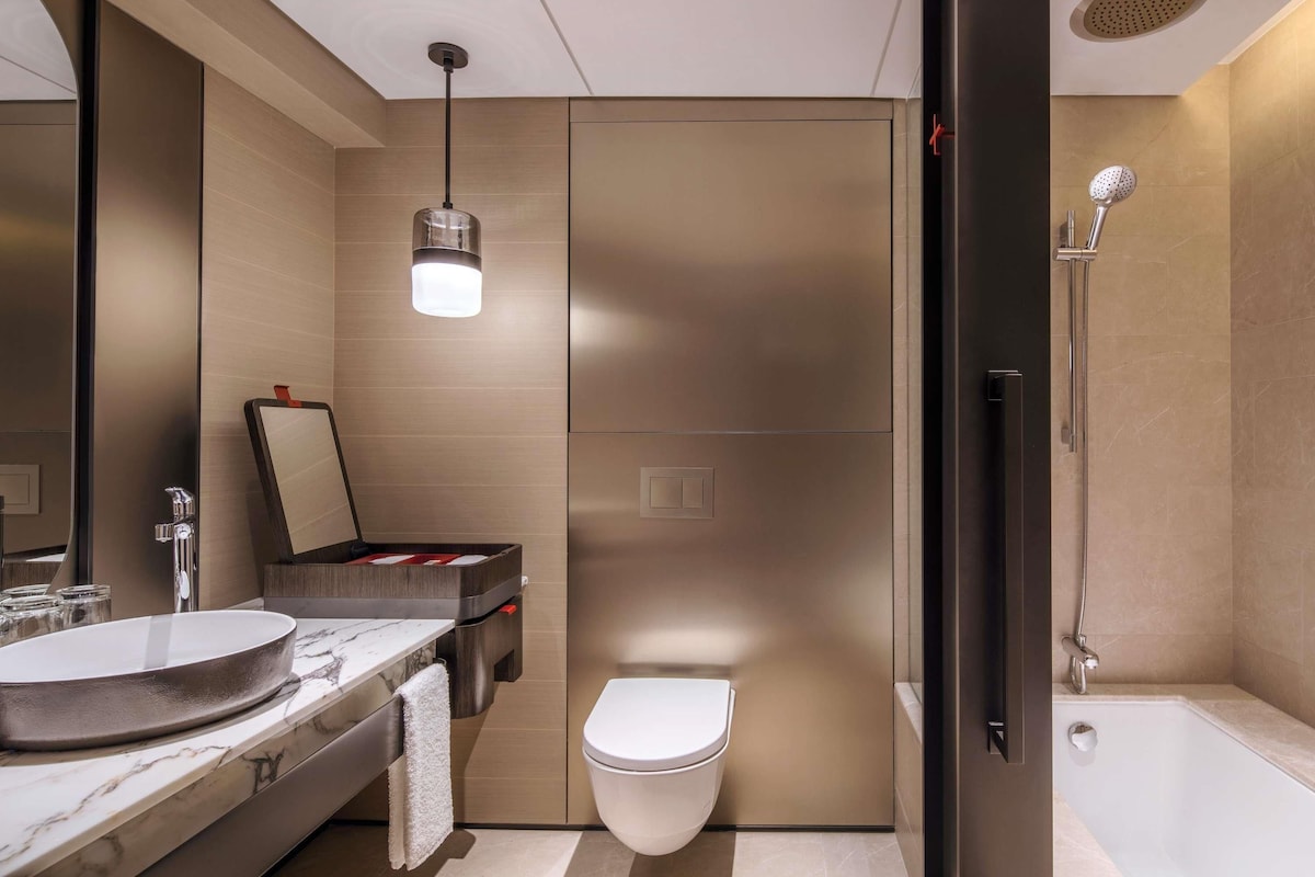 Une salle de bain moderne avec un lavabo en marbre, des toilettes et une douche.