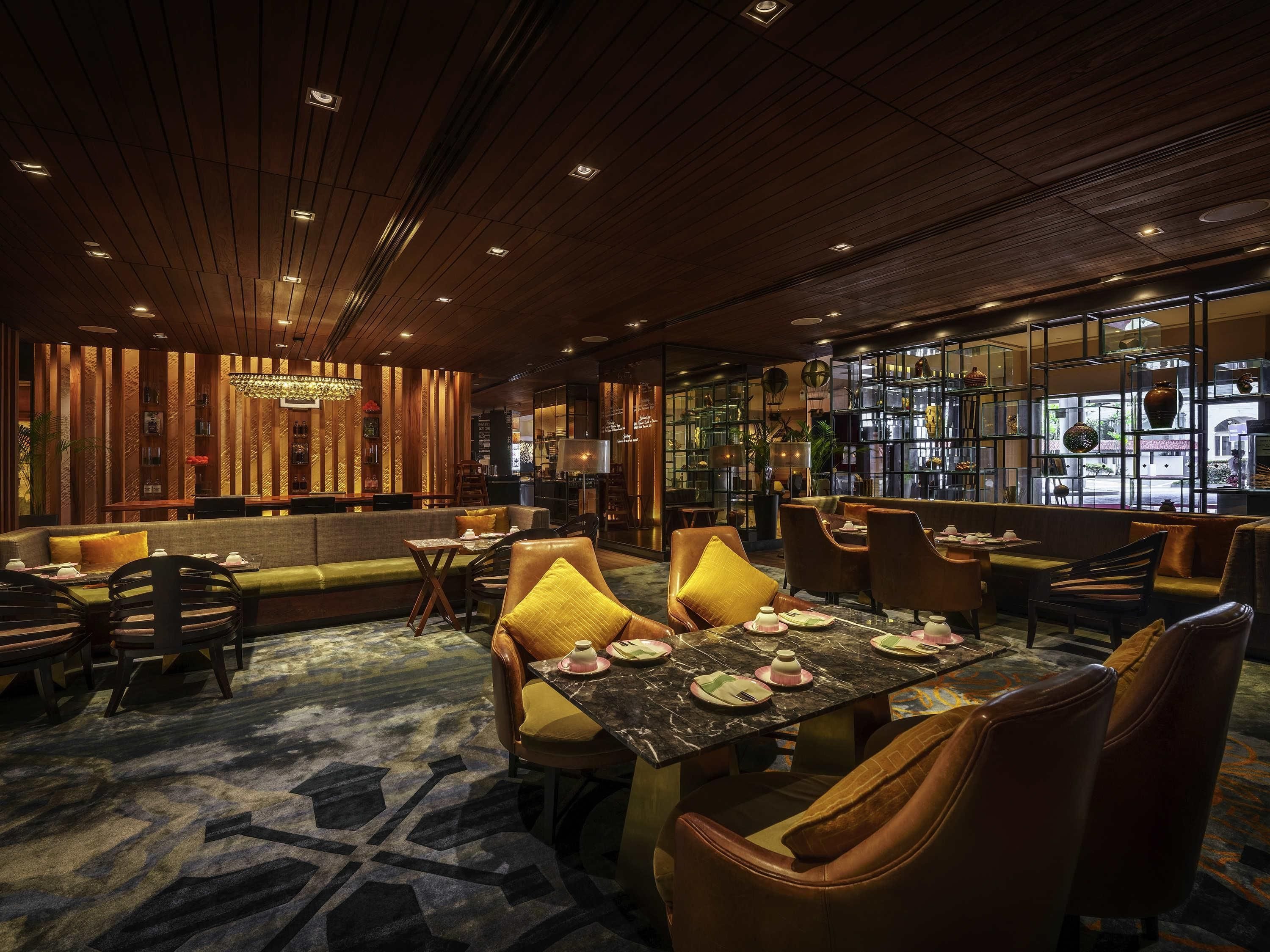 A restaurant with a wooden ceiling, cushioned seating, and a marble table.