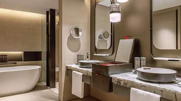A modern bathroom with a freestanding bathtub, two sinks with round basins, and a large mirror.