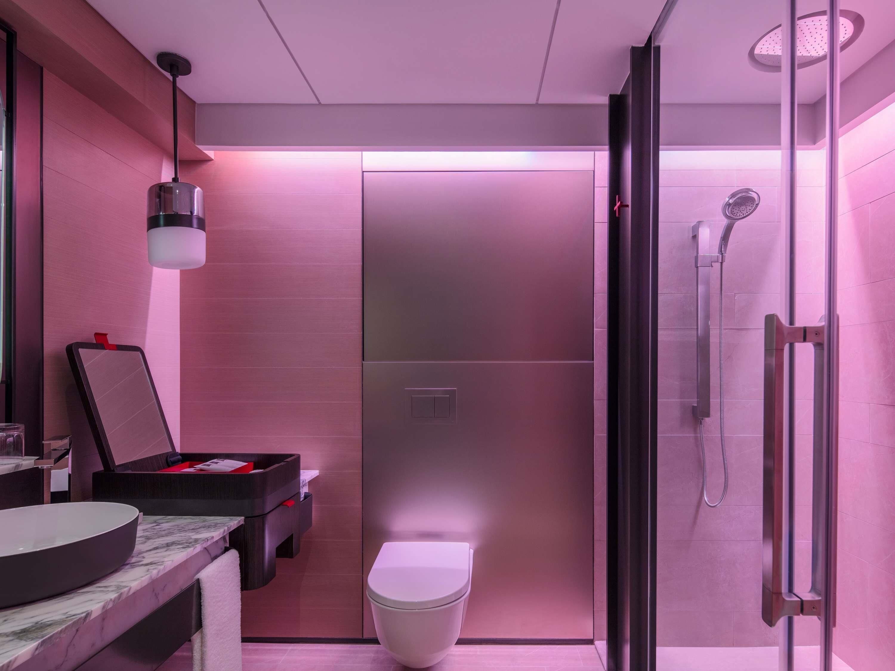 A modern bathroom with a toilet, a shower, and a vanity with a sink.