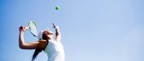 Una persona jugando al tenis.