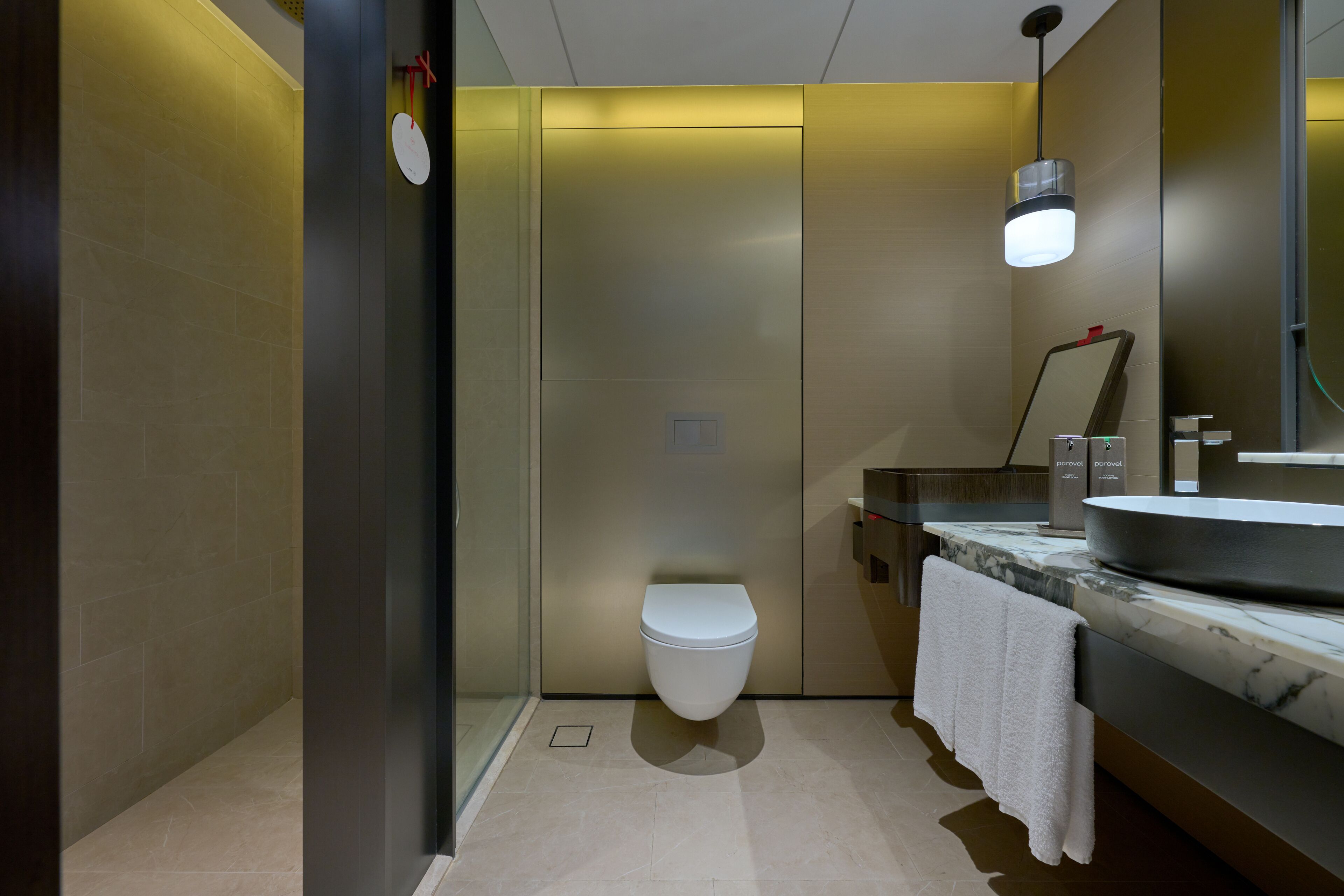 A modern bathroom with a toilet, sink, and mirror.