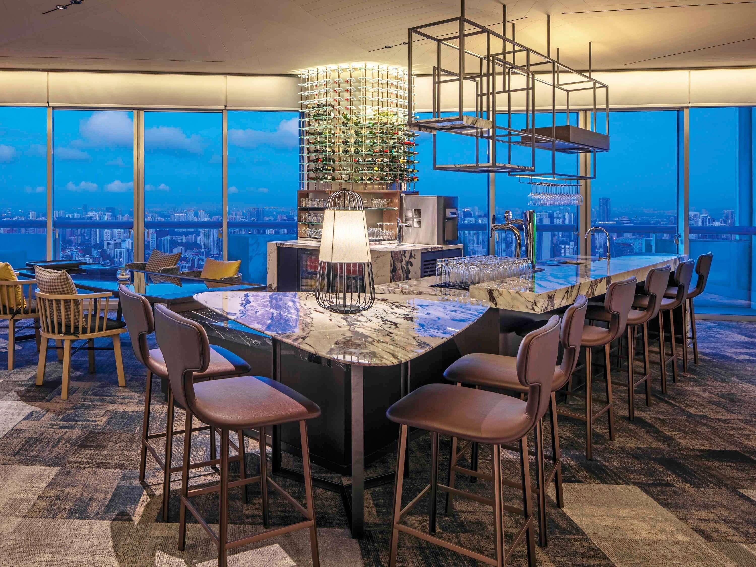 Uma área de bar moderna com vista para a cidade, balcão de mármore e adega.