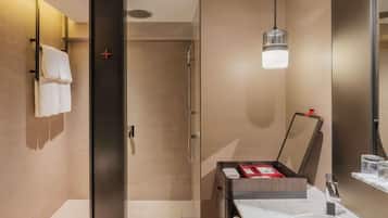 Une salle de bain moderne dotée d’une douche à parois de verre, d’un lavabo en marbre et d’un meuble-vasque intégré.