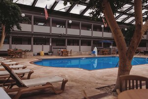 Una piscina techada, sillones reclinables de piscina