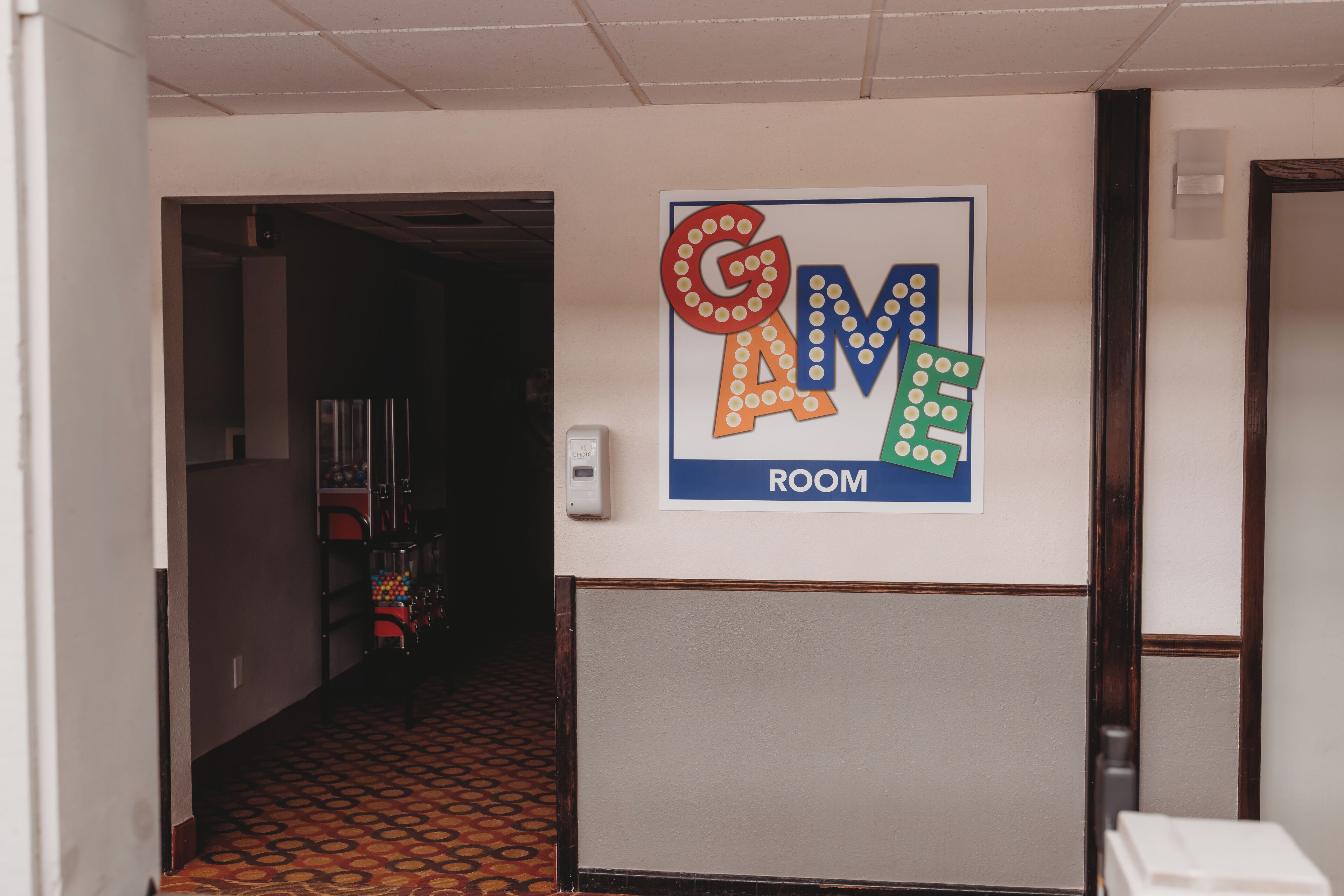 A hallway with a colorful sign indicating a room.