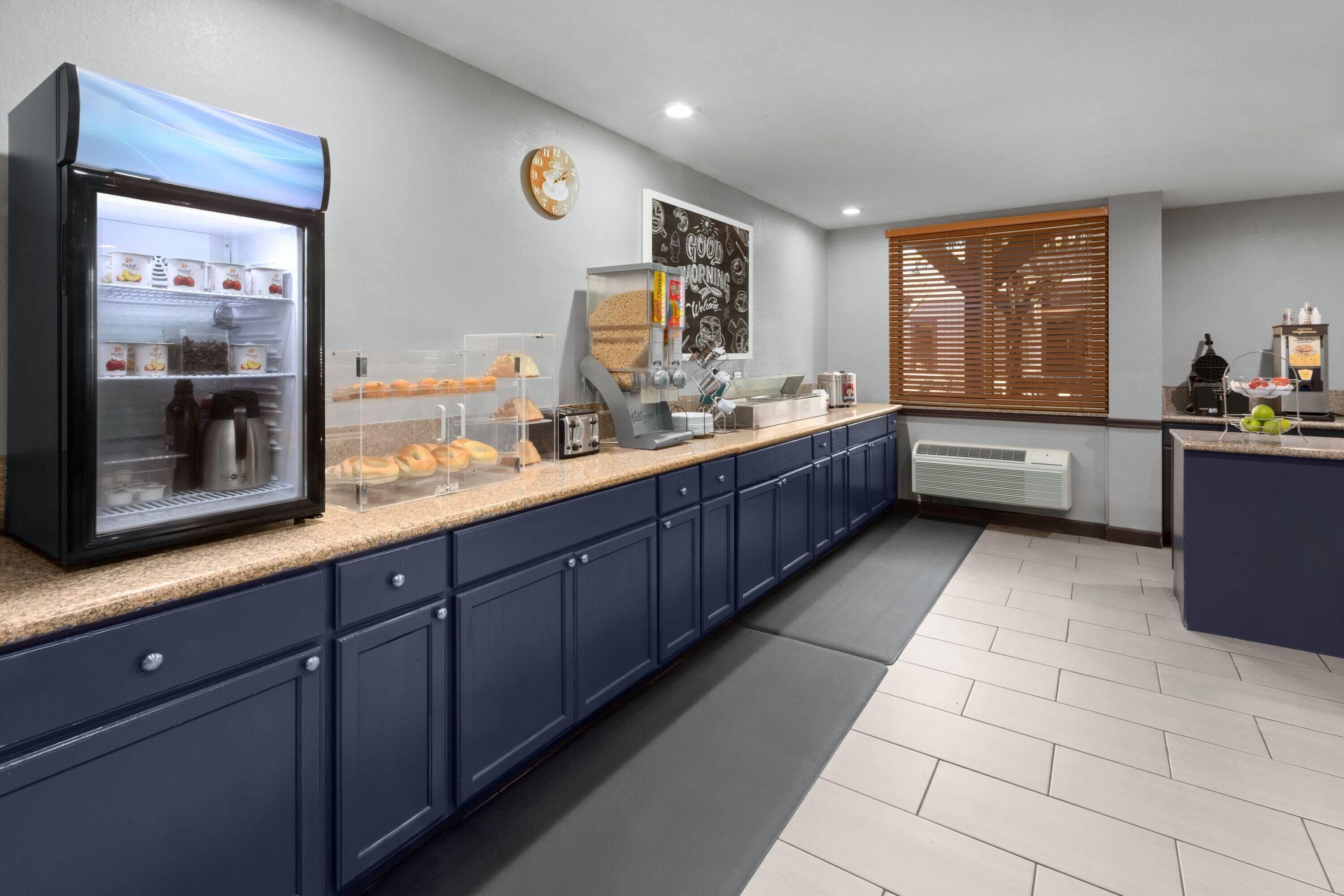 A modern kitchen with a self-service station, a clock, and a coffee machine.