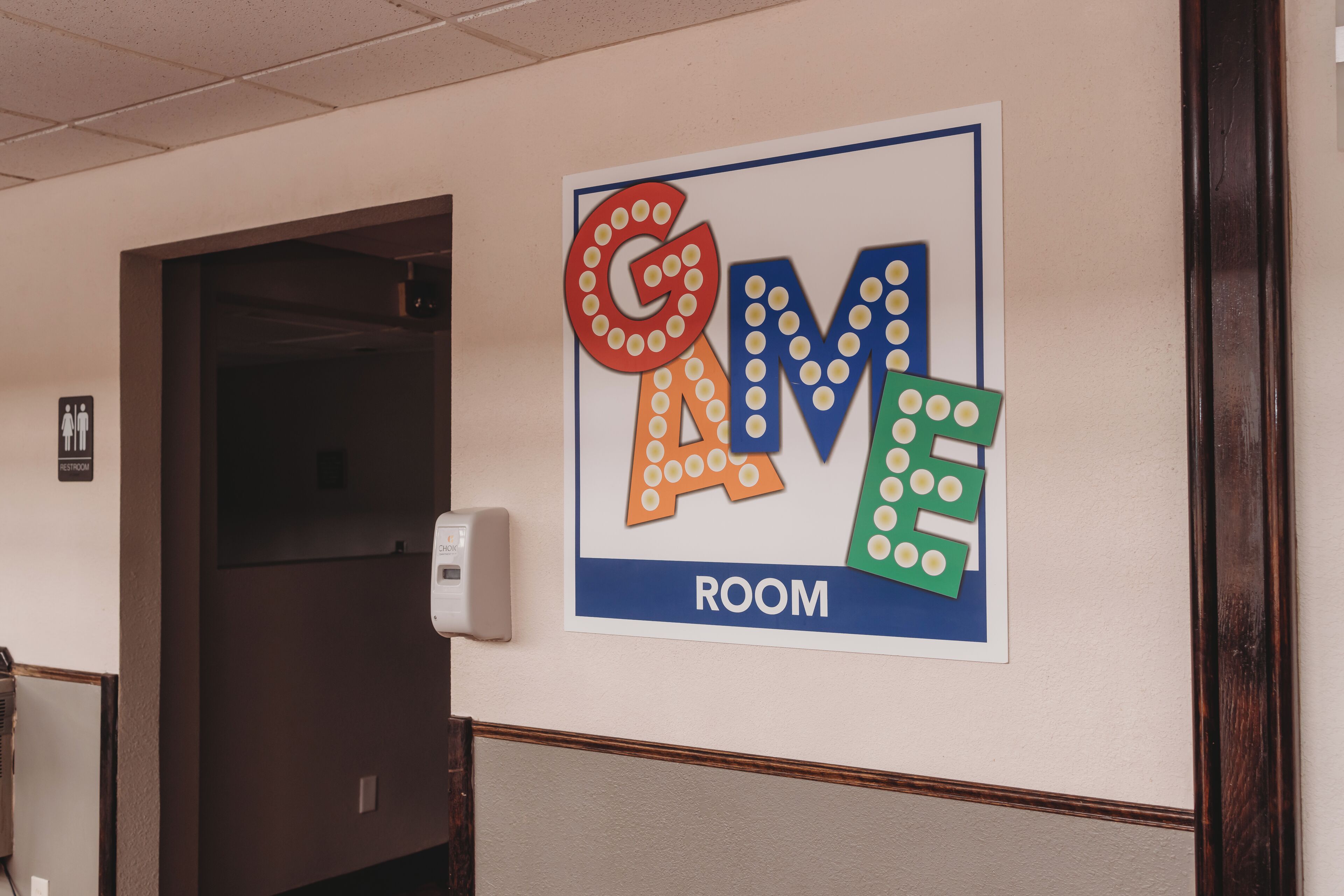 A hallway with a sign indicating a room labeled "GAME ROOM".