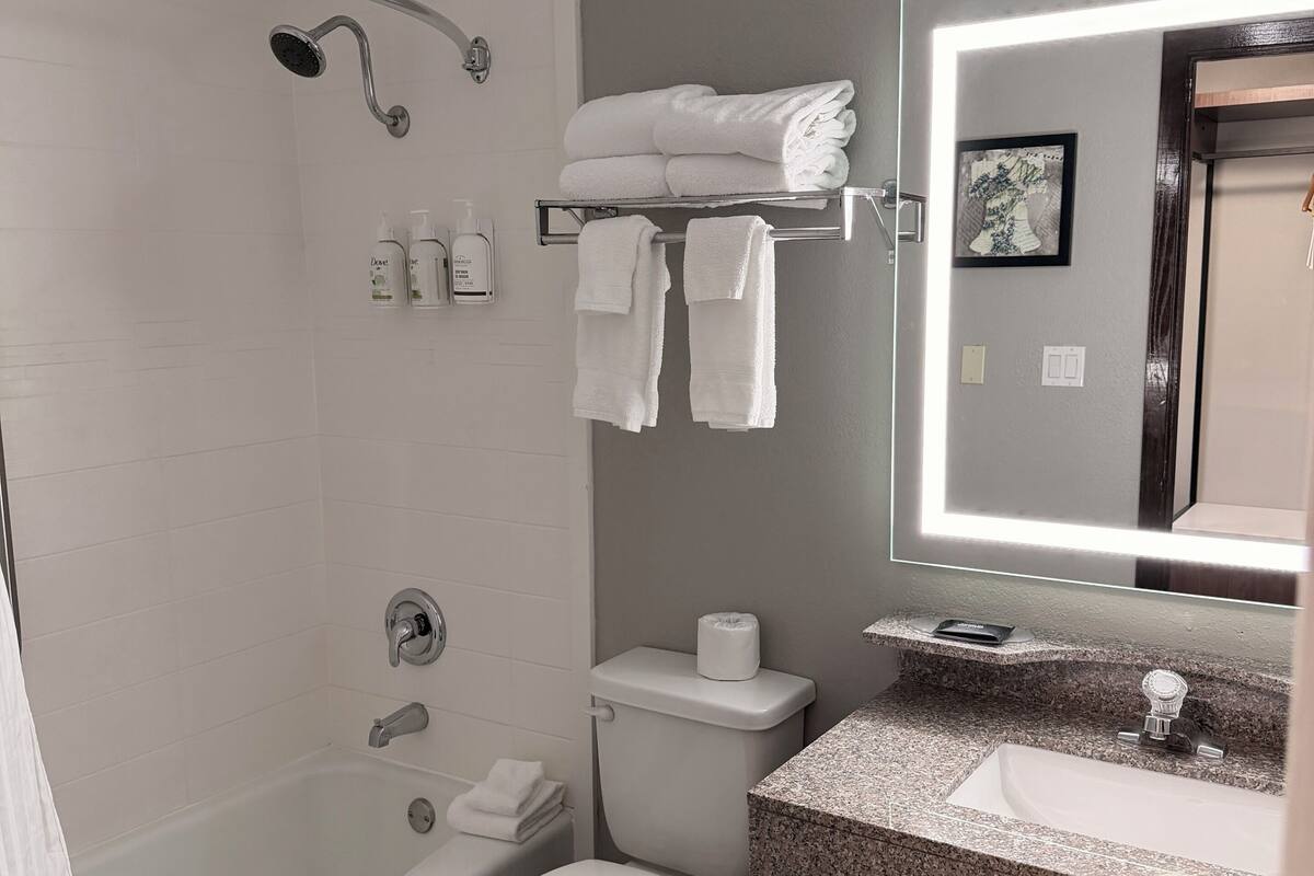A modern bathroom with a bathtub, toilet, and sink.