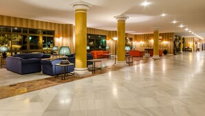 A spacious lobby with a marble floor, large columns, and seating areas with lamps. - Hotel Exe Guadalete (Jerez de la Frontera)