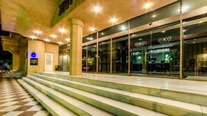 A hotel entrance with a checkered floor, steps leading up to the entrance, and glass doors. - Hotel Exe Guadalete (Jerez de la Frontera)