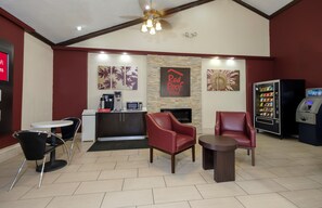 A Red Roof Inn lobby with a reception desk, seating area, and a vending machine. - Red Roof Inn New Orleans - Westbank (Harvey)