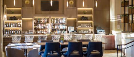A bar area with multiple seating options and a variety of liquor bottles.