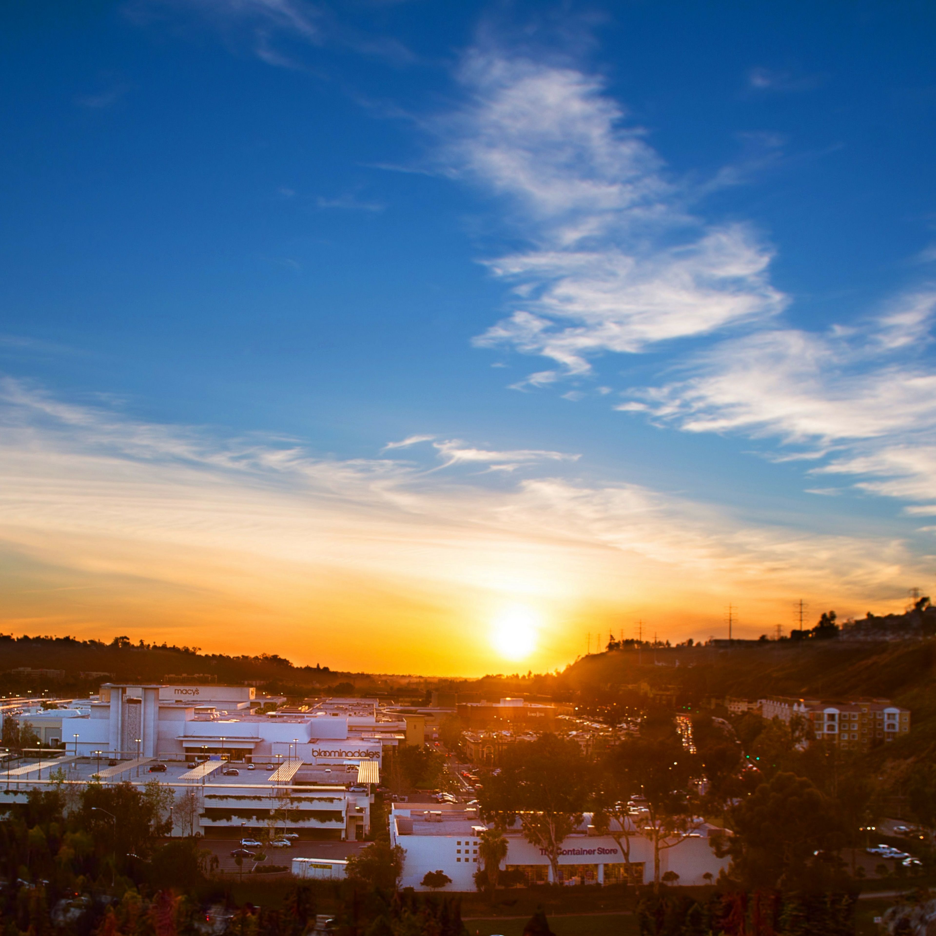 A cityscape at sunset with buildings and a clear sky.