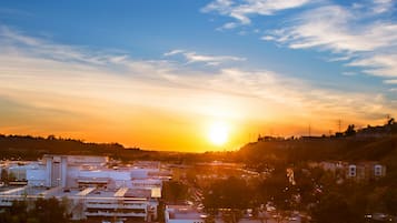 A cityscape at sunset with buildings and a clear sky.