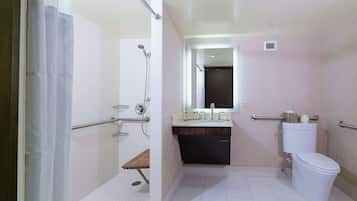 A modern bathroom with a shower, toilet, and sink.