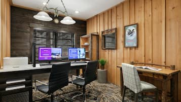 Ein moderner Büroarbeitsplatz mit Schreibtisch, zwei Stühlen, einem Computer und einem Drucker.