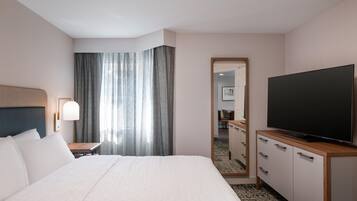A hotel room with a bed, a television, a desk, and a mirror.