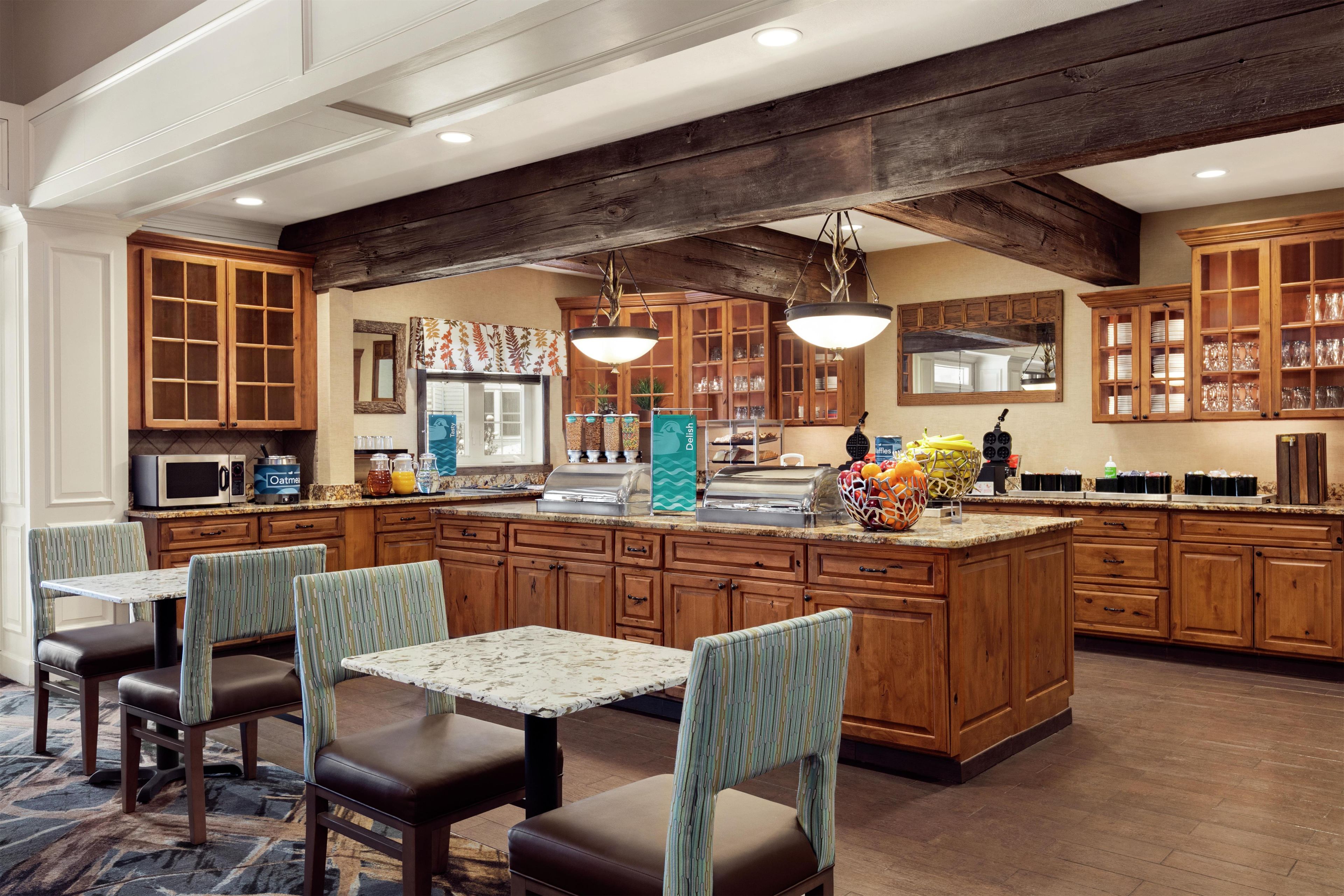 A spacious kitchen with wooden cabinets, a central island, and bar-style seating.